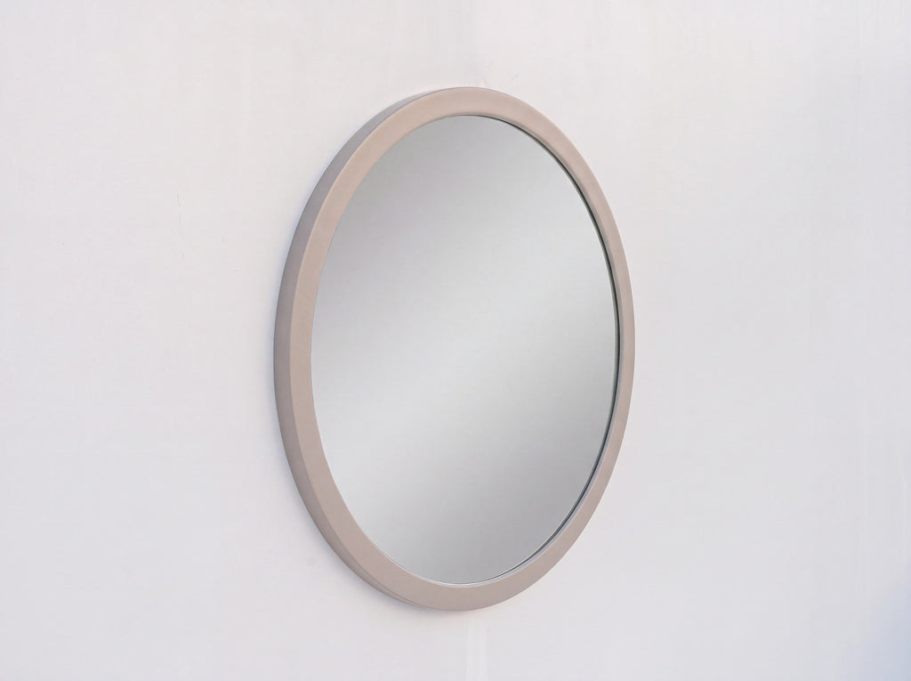 Arca round mirror with rounded taupe PU frame on a white wall, made in Dubai