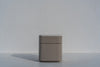 Arca curved bedside table with white stone top against a white wall, angled view