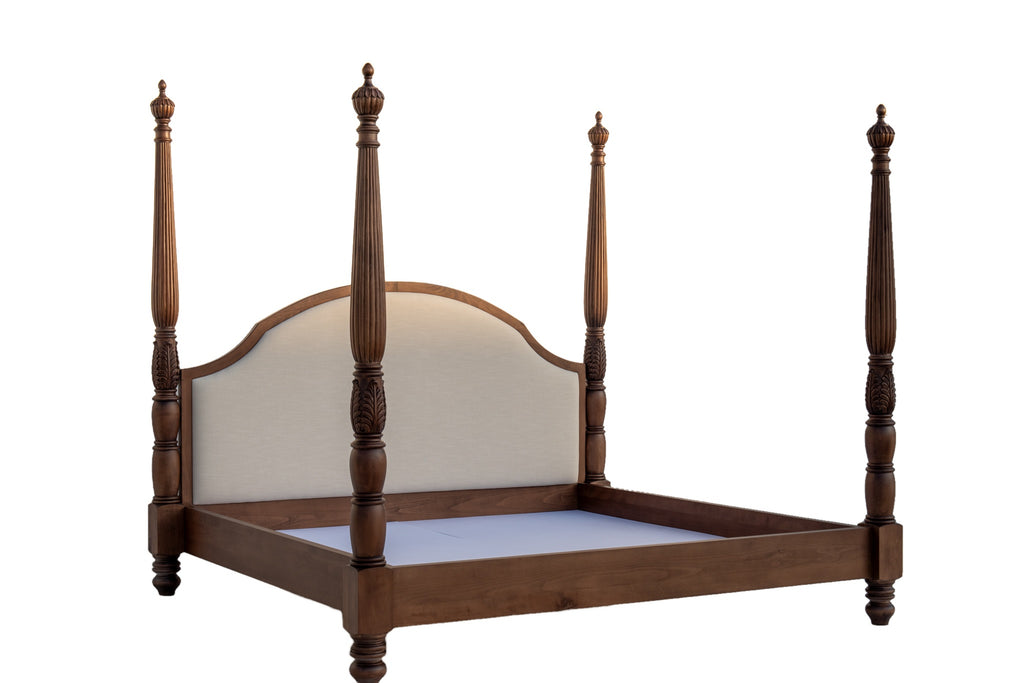 Carved four poster bed at an angle showing footboard post, side rail and linen headboard