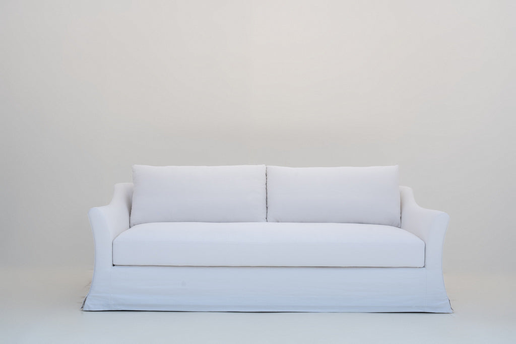 Slipcovered sofa in Dubai with a removable, washable white linen cover, front view