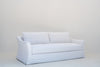 White Belgian linen sofa, three-quarter view with swoop arm and skirted base
