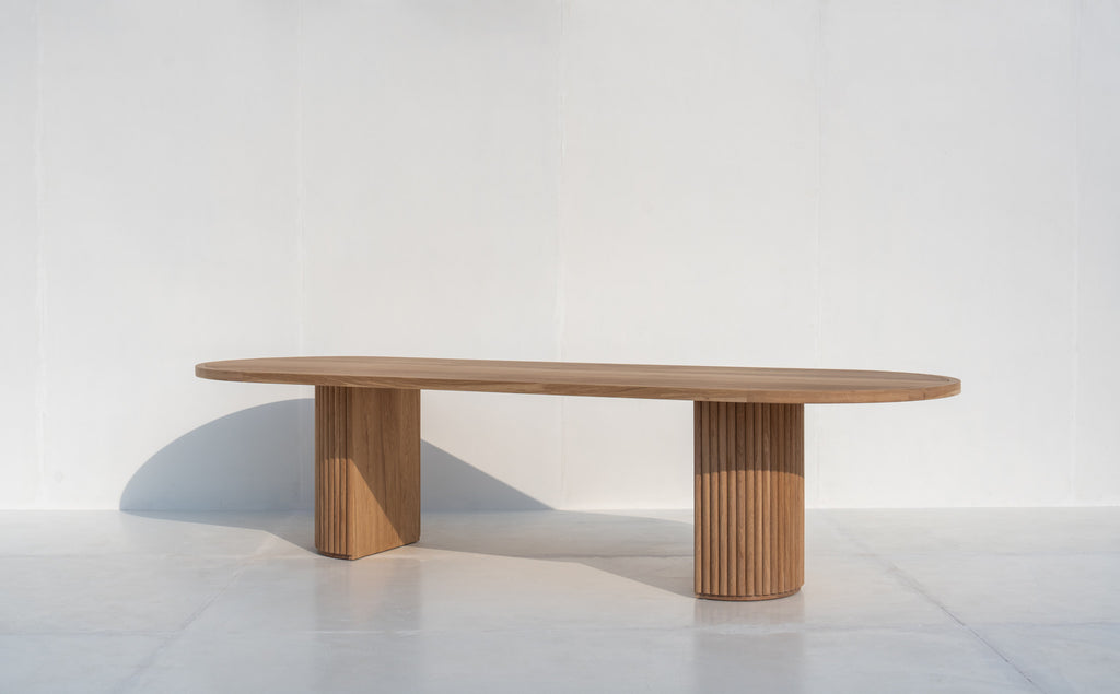 Oval solid oak dining table with sculptural fluted oak pedestal base