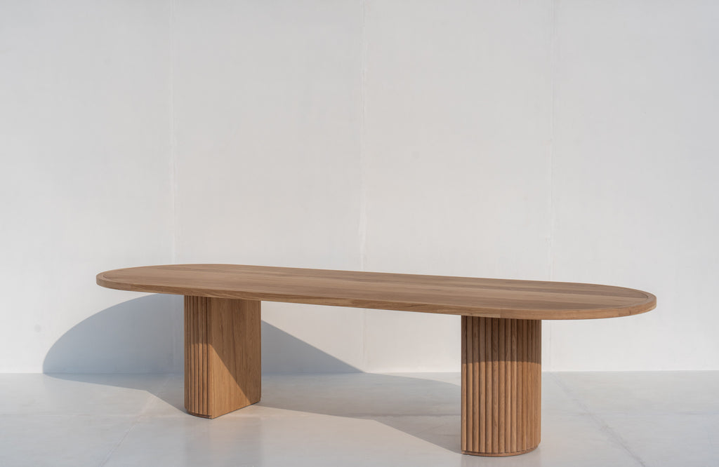 Oval solid oak dining table with sculptural fluted oak pedestal base