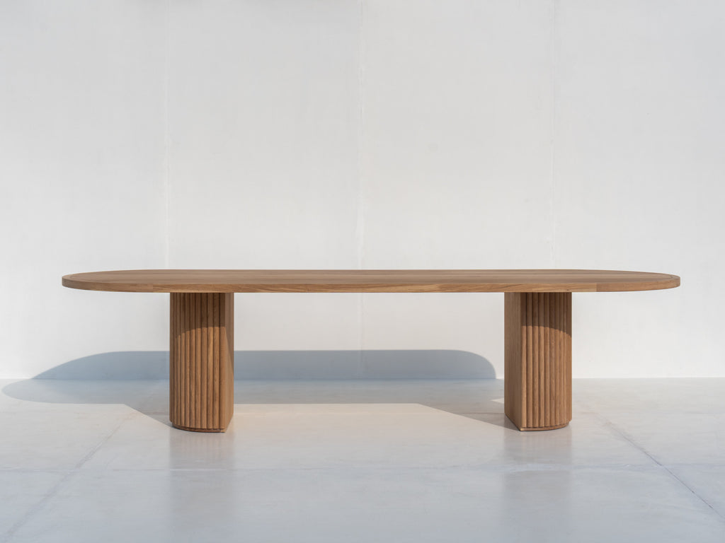 Oval solid oak dining table with sculptural fluted oak pedestal base