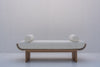 Solid oak upholstered bench featuring cylindrical bolster cushions