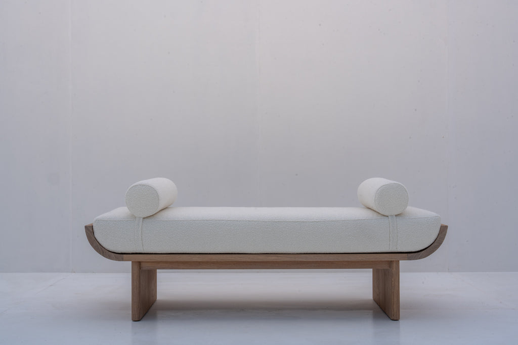 Solid oak upholstered bench featuring cylindrical bolster cushions