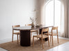 Livia Emperador marble dining table with woven dining chairs in a contemporary interior