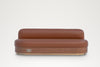 Tan leather banquette seat with wood-veneer base and brass double power socket, front elevation
