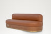 Marylebone Banquette three-quarter view, tan leather seat on a curved veneer and brass base