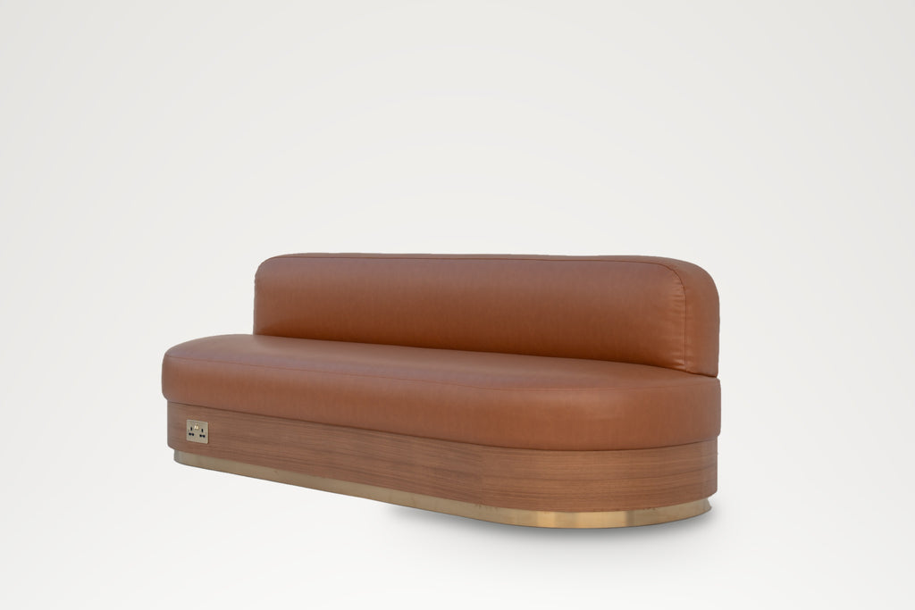 Restaurant booth banquette in tan leather with built-in power socket and brass plinth