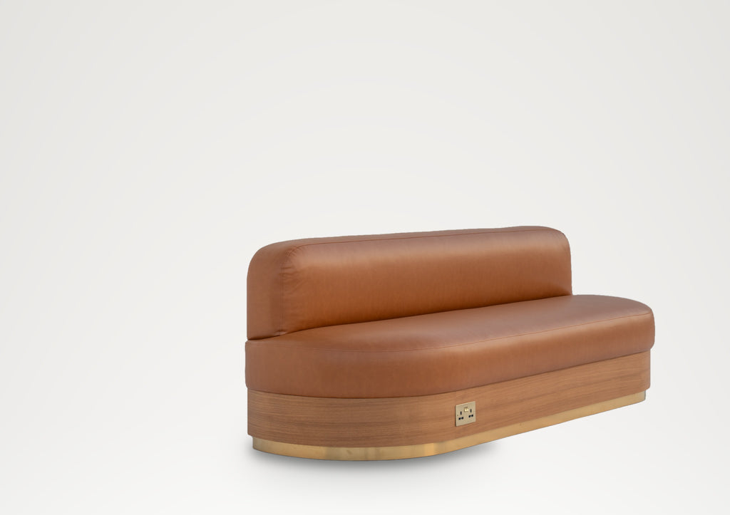 Marylebone tan leather banquette, side angle showing the rounded seat end and brass trim