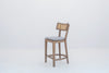 Ojai solid oak bar chair with oak footring and brushed brass kick plate, three-quarter view