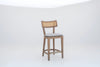 Oak and cane counter stool with curved backrest and brass footrest, angled view