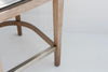 Close-up of the tapered oak legs, curved oak footring and brushed brass footrest
