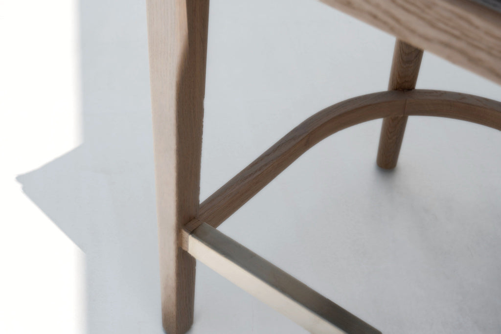 Solid oak leg joinery and brass footrest detail on the Ojai counter stool