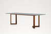 Pietra dining table, angled view from the right showing the teak frame and rounded stone corners