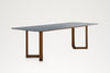 Pietra dining table, angled view of the V-shaped teak foot and stone top