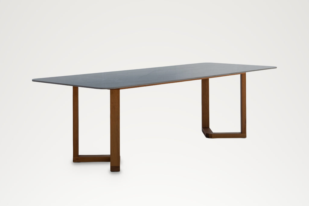 Pietra dining table, angled view of the V-shaped teak foot and stone top