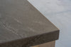 Corner detail of the Pietra bar table outdoor stone top with natural texture