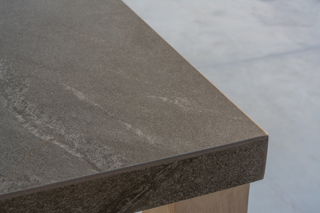 Corner detail of the Pietra bar table outdoor stone top with natural texture