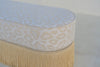Close-up of ivory leopard jacquard upholstery and self piping on the Savannah bench