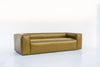 Modern leather sofa with a low back and deep bench seat, angled view