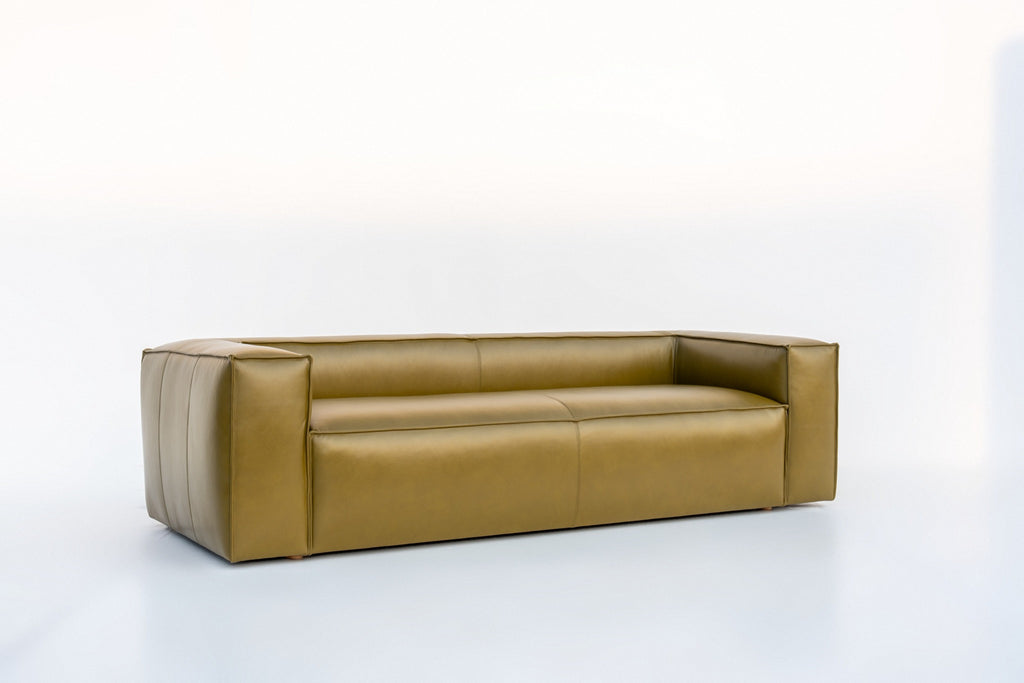 Modern leather sofa with a low back and deep bench seat, angled view